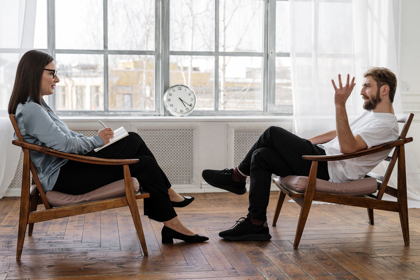 A therapist and a patient speaking across two chairs