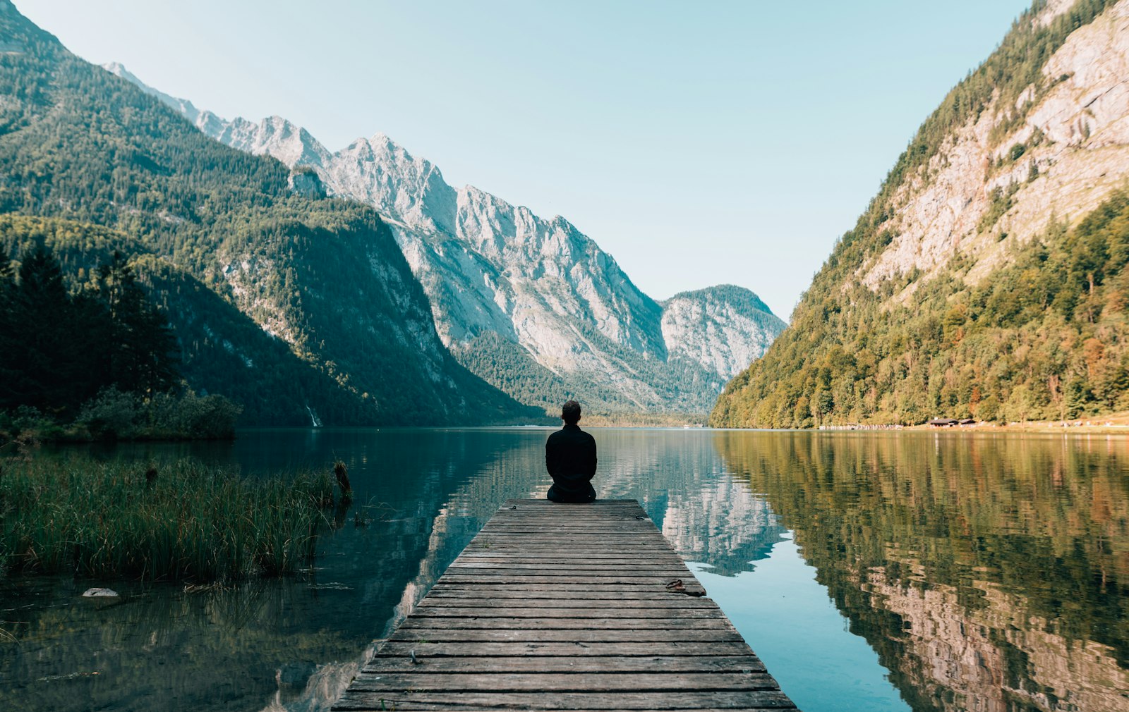 A lone figure at the end of a wooden dock